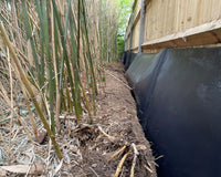 Image of root barrier membrane installed next to a fence with bamboo next to it