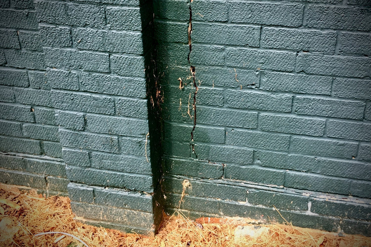 vertical crack in a wall painted black as a result of subsidence