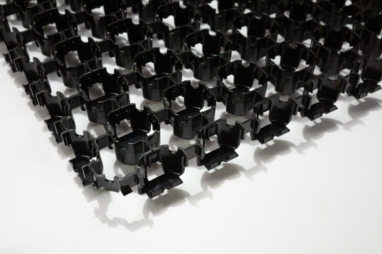 Close up of black Terram Bodpave 40 permeable paving grid on a white background
